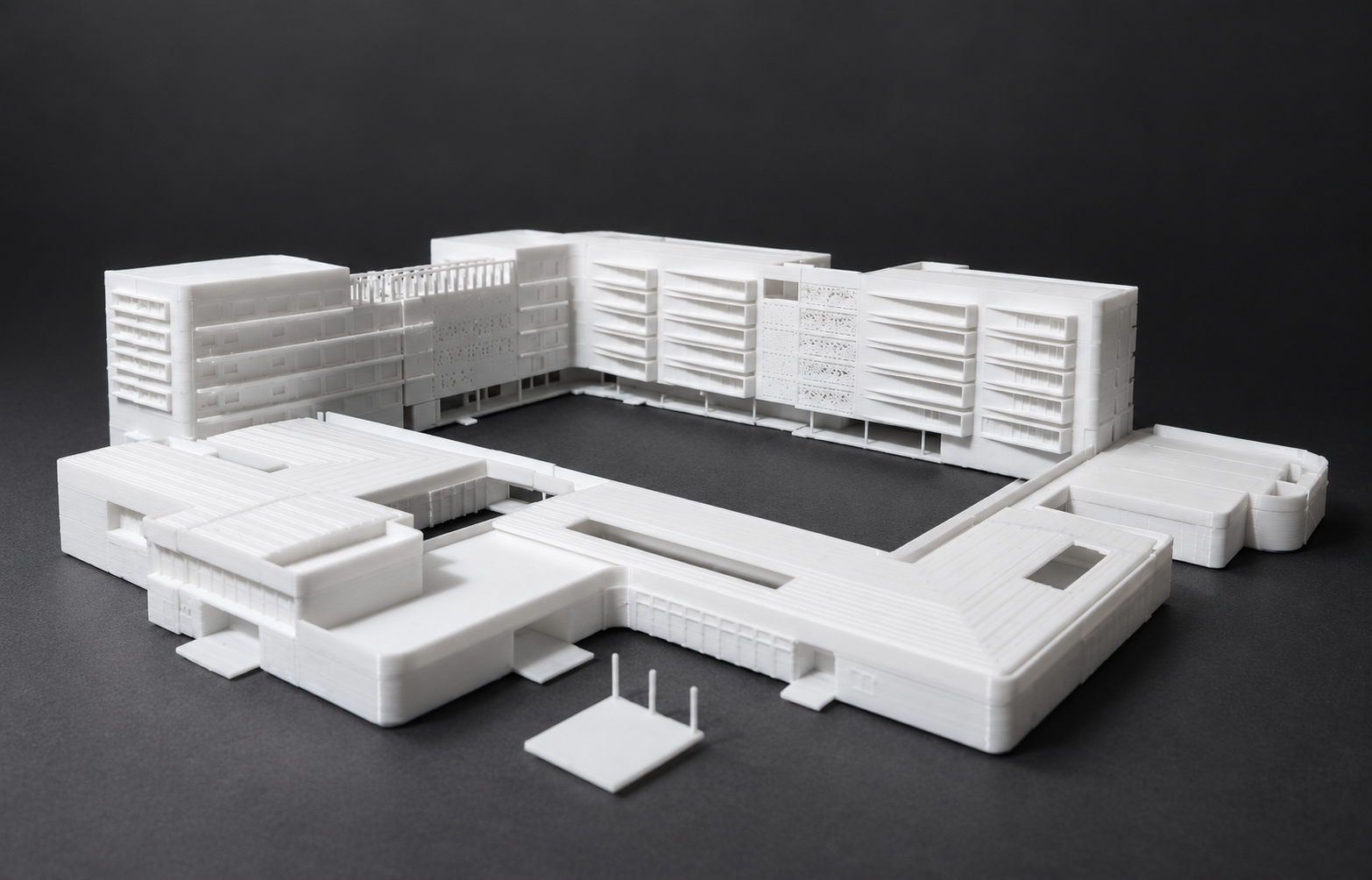 White courtyard complex with tall rear wings and low foreground buildings