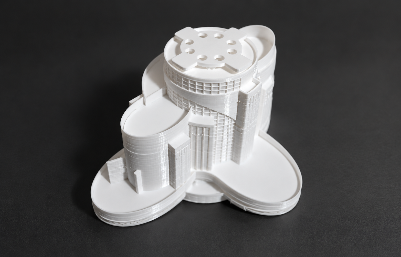 White curved architectural model with circular roof openings